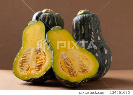 Half green butternut squash pumpkin on brown background 134361620