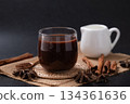 Hot chocolate in glass and star anise and cinnamon sticks on black background 134361636