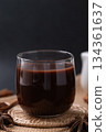 Hot chocolate in glass and star anise and cinnamon sticks on black background 134361637