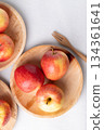 Red apple fruit (Gala apple) in natural plate with wooden fork on white background, Top view 134361641