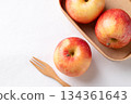 Red apple fruit (Gala apple) in natural bowl with wooden fork on white background, Top view 134361643