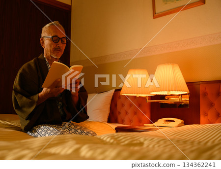 Senior man in yukata reading a book at a hotel Senior man in yukata reading a book at a hotel 134362241