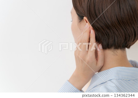Back view of a woman covering her ears Back view of a woman covering her ears 134362344