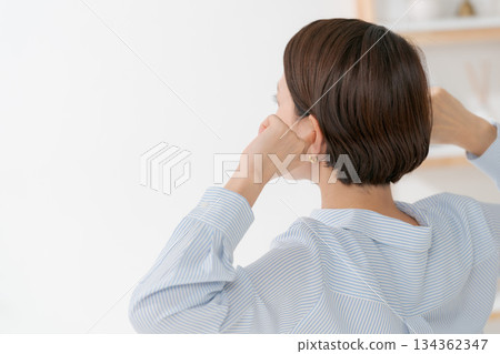 Back view of a woman covering her ears 134362347