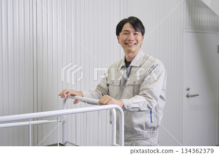 Worker carrying a cart looking at the camera Worker carrying a cart looking at the camera 134362379