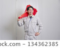 Worker holding a traffic cone, warehouse portrait 134362385