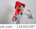 Worker holding a traffic cone, fist pump, warehouse 134362387