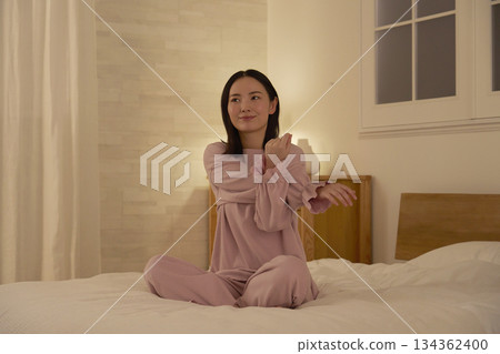 Woman stretching her arms on the bed 134362400