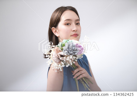 Woman in a blue blouse holding a bouquet 134362425