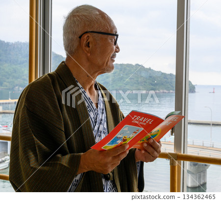 Senior man planning a trip at a hot spring inn 134362465