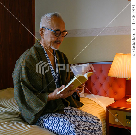 An elderly man enjoying reading at a ryokan 134362471