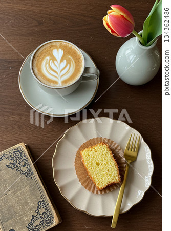 Latte Art Coffee with Pound Cake Slice and Tulip on Wooden Table 134362486
