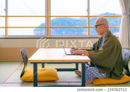 Senior man working on a PC in a Japanese-style room Senior man working on a PC in a Japanese-style room 134362512