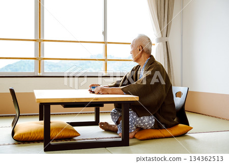 一位身著傳統日式服裝的老者在窗邊休憩。 134362513