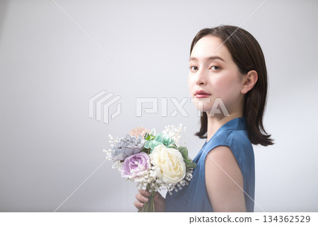 身穿藍色襯衫的女子手捧花束 身穿藍色襯衫的女子手捧花束 134362529