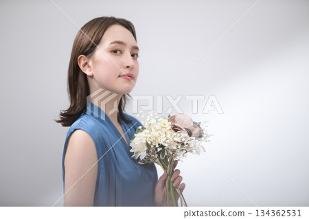身穿藍色襯衫的女子手捧花束 身穿藍色襯衫的女子手捧花束 134362531