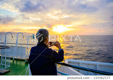 黃昏時分，有人在渡輪上拍攝日落。 134362577