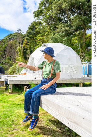 一位老婦人指著一處豪華露營設施 [照片由沖繩海濱飯店雅提供] 134362581