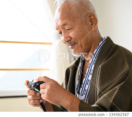 A man in traditional Japanese clothing operates the camera A man in traditional Japanese clothing operates the camera 134362587