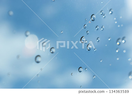 water drop on mirror with blue sky and white cloud background 134363589