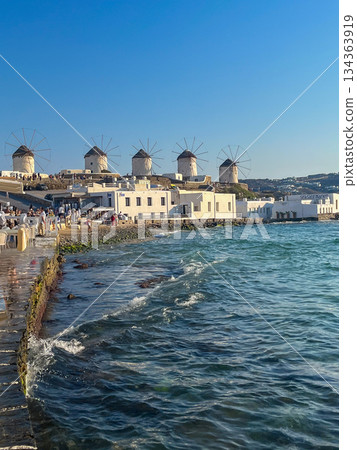 Mykonos' iconic white windmills embodying greek island culture, architecture, and tourism against a clear sky. Copy space Mykonos' iconic white windmills embodying greek island culture, architecture, and tourism against a clear sky. Copy space 134363919