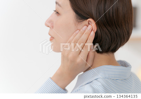 一位摀著耳朵的女士側臉 一位摀著耳朵的女士側臉 134364135