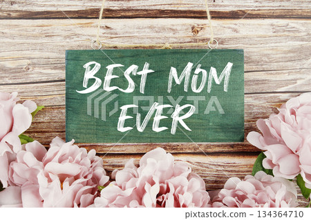 Best Mom Ever text written on wooden plank with flower decoration on wooden background Best Mom Ever text written on wooden plank with flower decoration on wooden background 134364710