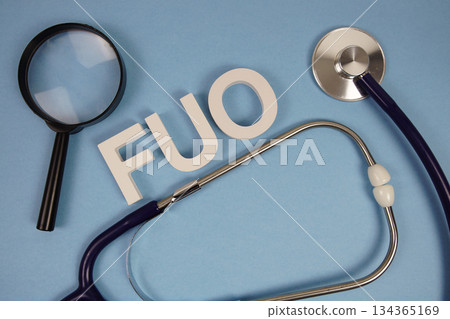 FUO Fever Of Unknown Origin text with Stethoscope and magnifying glass on blue background FUO Fever Of Unknown Origin text with Stethoscope and magnifying glass on blue background 134365169