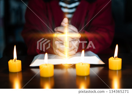 Christian hand while praying and worship for christian religion with blurred of her body background, Casual man praying with her hands together over a closed Bible. christian background. freedom. 134365271