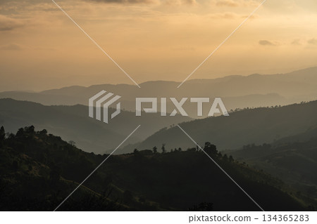Serene Mountain Landscape at Dusk with Layered Hills and Soft Hues in the Sky Offering a Tranquil Nature Escape for Adventurous Souls Serene Mountain Landscape at Dusk with Layered Hills and Soft Hues in the Sky Offering a Tranquil Nature Escape for Adventurous Souls 134365283