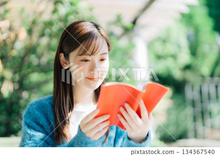 在露台上閱讀的年輕女子 134367540