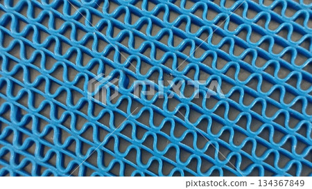 A high-angle shot shows a vibrant blue vinyl loop matting, perfect for heavy-duty use. Ideal for entrances and wet areas, this mat combines functionality with style. 134367849
