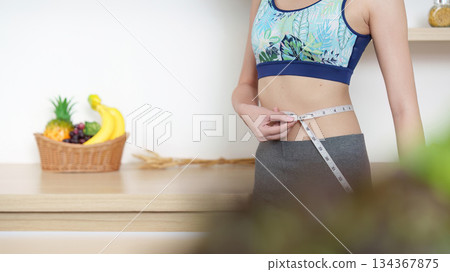 Measuring Waist for Fitness Goals. A person tracking health progress with a tape measure. Measuring Waist for Fitness Goals. A person tracking health progress with a tape measure. 134367875