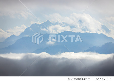Landscape of Morning Mist with Mountain Layer. mountain ridge and clouds in rural jungle bush forest Landscape of Morning Mist with Mountain Layer. mountain ridge and clouds in rural jungle bush forest 134367928