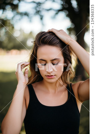 Woman in a Black Top Enjoying a Serene Moment Outdoors in a Natural Setting During Daylight Woman in a Black Top Enjoying a Serene Moment Outdoors in a Natural Setting During Daylight 134368335
