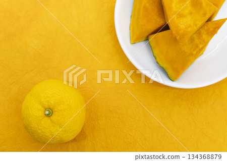 Cut pumpkin and yuzu placed on a yellow Japanese paper background Image of the winter solstice 134368879