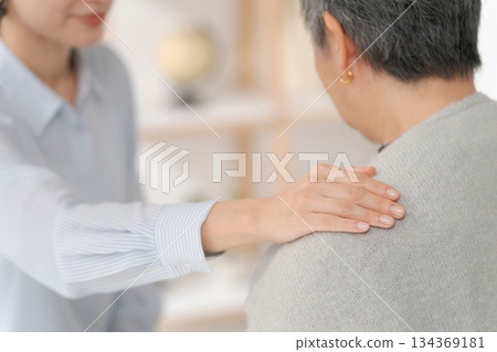 A woman in her 30s putting her hand on a middle-aged woman's shoulder A woman in her 30s putting her hand on a middle-aged woman's shoulder 134369181