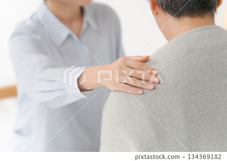 A woman in her 30s putting her hand on a middle-aged woman's shoulder A woman in her 30s putting her hand on a middle-aged woman's shoulder 134369182