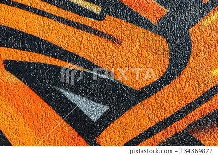 Vibrant Orange Graffiti Art with Bold Black Lines Textured on Urban Wall Vibrant Orange Graffiti Art with Bold Black Lines Textured on Urban Wall 134369872
