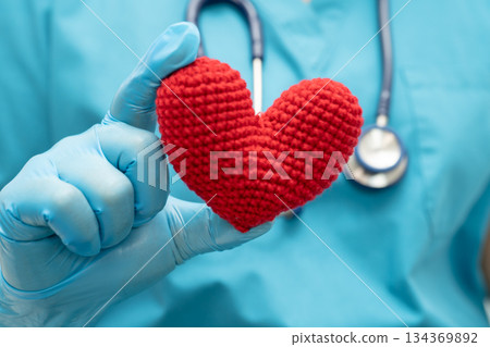 Doctor holding a red heart in hospital ward, healthy strong medical concept. 134369892