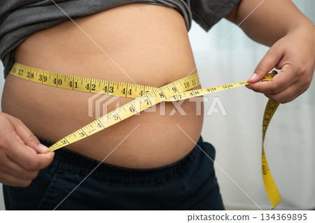 Asian woman with fat belly big size overweight and obesity with measure tape. Asian woman with fat belly big size overweight and obesity with measure tape. 134369895