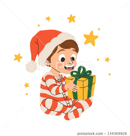 Vector illustration of cartoon happy little boy smiling, sitting in striped pajamas and red santa hat holding present with a bow for christmas. 134369926