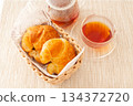 Croissants and healthy rooibos tea served in a basket 134372720