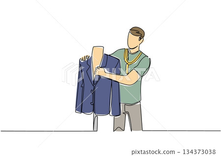 A young man tailor measures a formal jacket on a mannequin with tape in continuous line drawing style, highlighting business concept and skill craftsmanship for National Tailors Day theme. 134373038