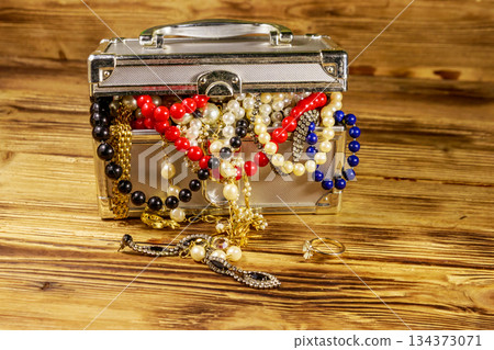 Jewelry box full of jewelry and accessories on wooden background Jewelry box full of jewelry and accessories on wooden background 134373071