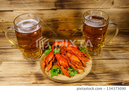 Boiled crayfish and two mugs of beer on a wooden table 134373090