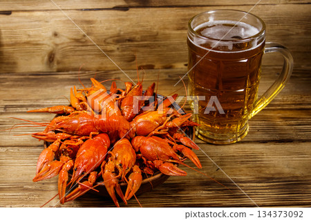 Boiled crayfish and mug of beer on a wooden table 134373092