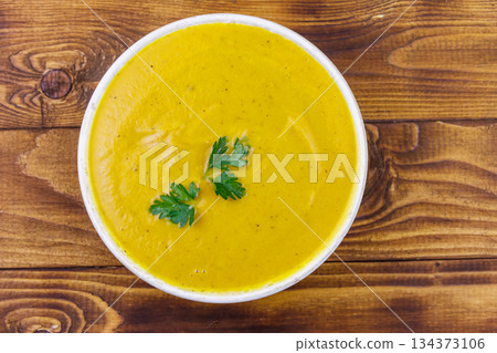 Pumpkin soup on a wooden table. Top view Pumpkin soup on a wooden table. Top view 134373106