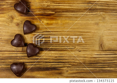 Heart shaped chocolate candies on wooden background. Top view, copy space. Valentine Day concept 134373115