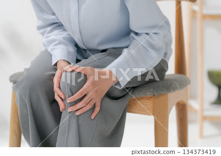 Woman holding her knees Woman holding her knees 134373419